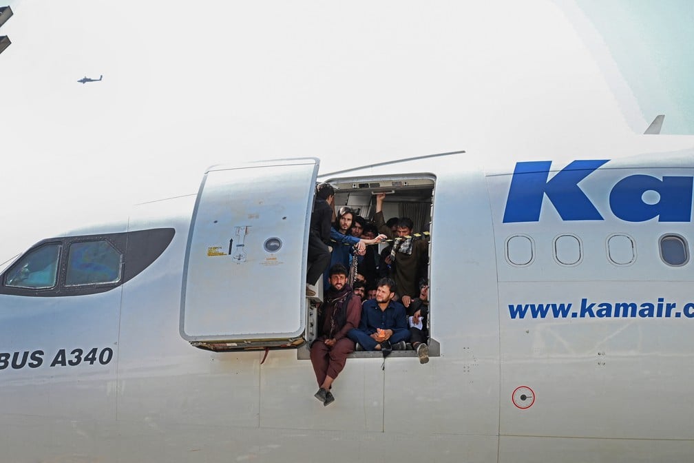 Afegãos lotam avião no aeroporto de Cabul para tentar fugir do Talibã no Afeganistão. Reprodução/ AFP