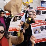 Familiares de réfens do Hamas durante manifestação diante da casa do secretário-geral da ONU, Antonio Guterres, em Nova York, no dia 15 de dezembro. (Reprodução/AFP/MICHAEL M. SANTIAGO).