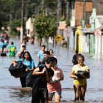 Pessoas deixando suas casas alagadas