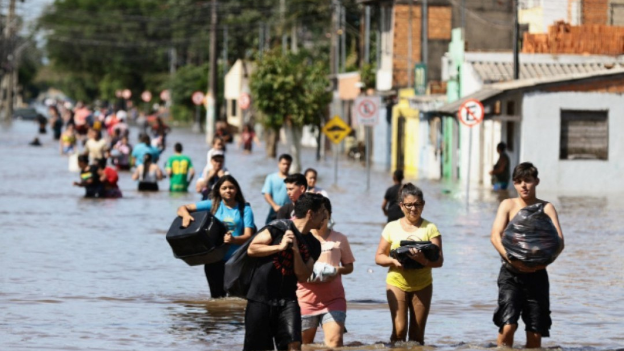 Pessoas deixando suas casas alagadas