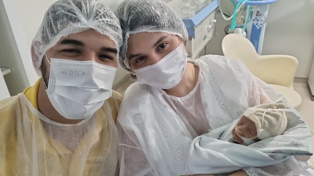 Foto do casal Zé Vaqueiro e Inga Soares no hospital com seu filho Arthur no colo