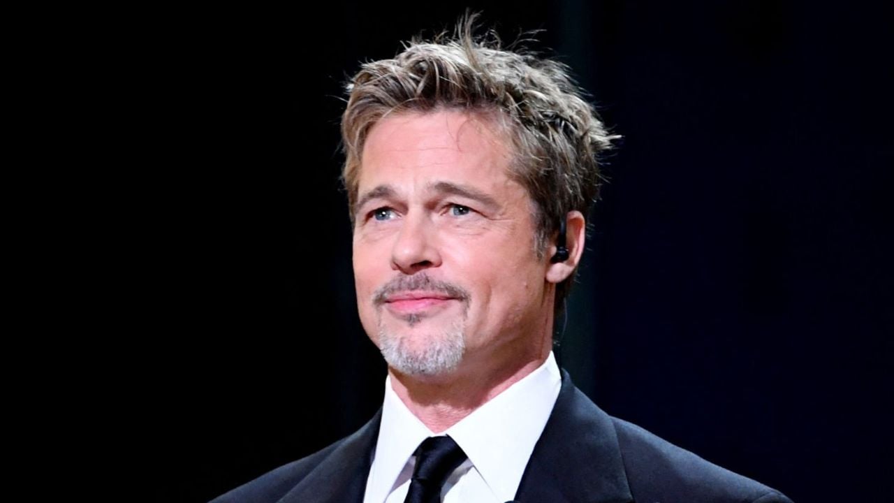 Brad Pitt vestindo um terno em frente a fundo preto.