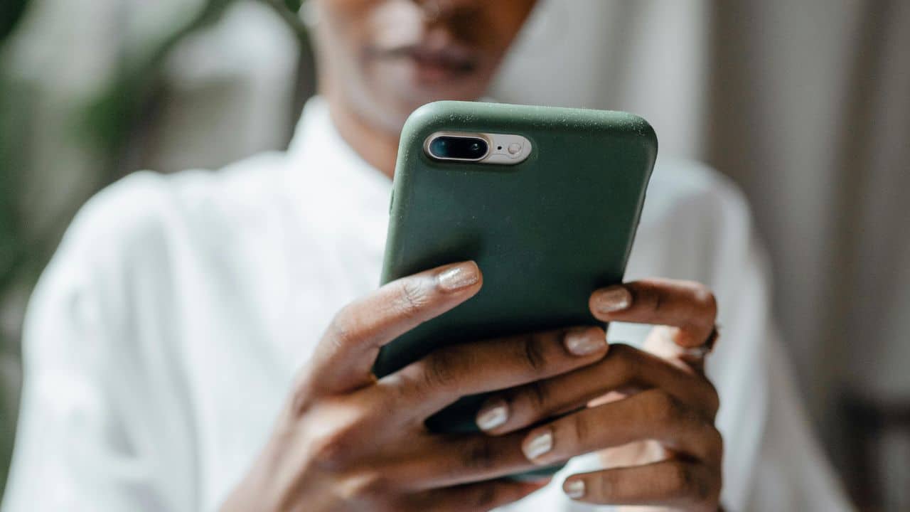 mulher segurando um celular nas mãos