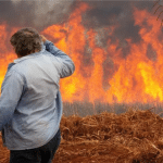 Homem observa incêndio em plantação de cana-de-açúcar (JOEL SILVA/Reuters/noticias.uol.com.br)