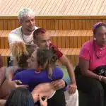 Participantes do reality show "Estrela da Casa" estão sentados em um ambiente descontraído ponto dois do grupo azul estão se abraçando demonstrando União e camaradagem após a dinâmica de composição.