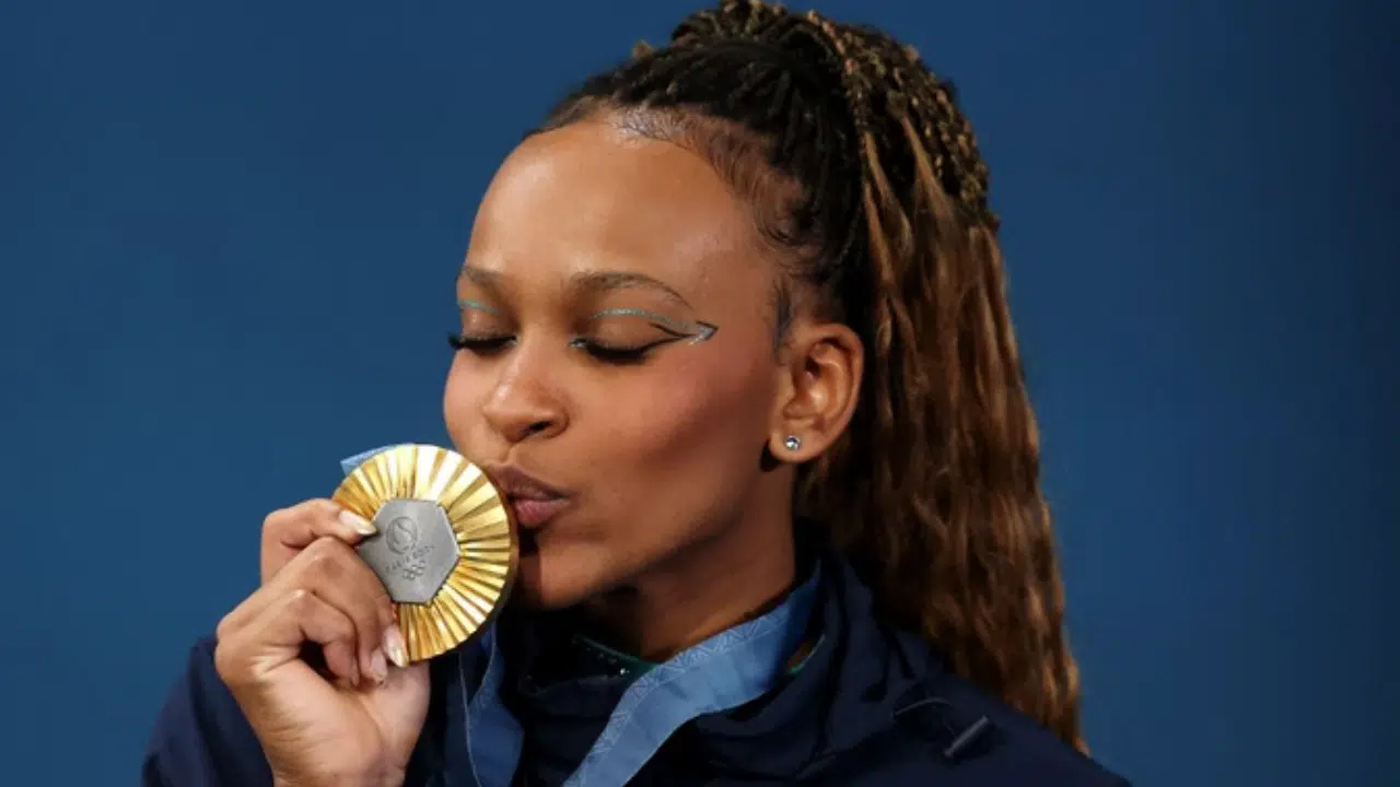 Rebeca beijando medalha de ouro