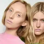 Duas modelos usando batom rosa-claro em desfile de moda.