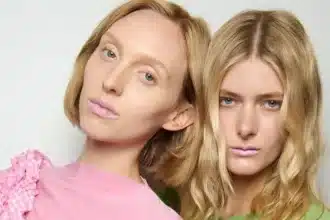 Duas modelos usando batom rosa-claro em desfile de moda.