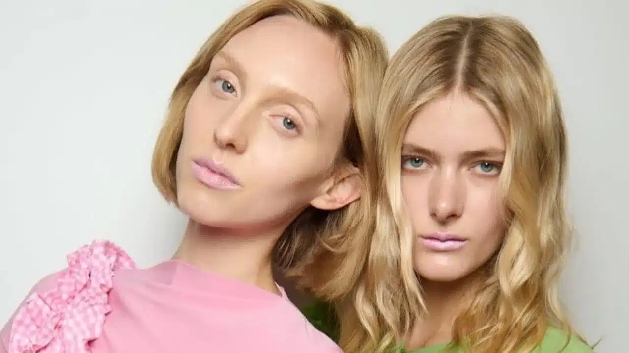 Duas modelos usando batom rosa-claro em desfile de moda.