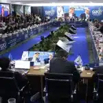 Mesa redonda do G20 com vários líderes e representantes das maiores economias do mundo, reunidos para discutir economia digital, com um painel de fundo com o logotipo do G20 Brasil 2024.