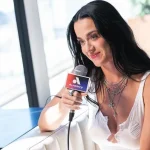 Katy Perry aparece em sacada de hotel com bandeira do Brasil