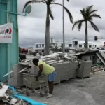 Pessoas limpando destroços