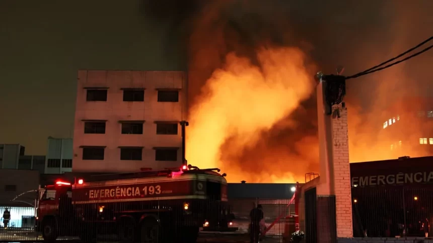 Caminhão do Corpo de Bombeiros combate incêndio no Shopping 25 de Março, no Brás, São Paulo, em meio a intensas chamas e fumaça densa