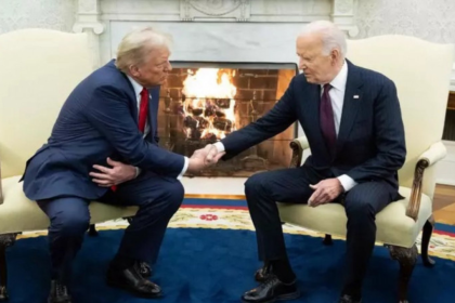 "onald Trump e Joe Biden apertam as mãos durante uma reunião formal em um ambiente elegante, com uma lareira acesa ao fundo