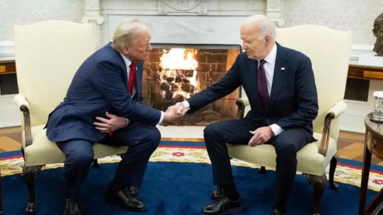 "onald Trump e Joe Biden apertam as mãos durante uma reunião formal em um ambiente elegante, com uma lareira acesa ao fundo