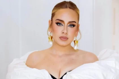 Cantora Adele, acusada de plágio, usando vestido branco em foto formal