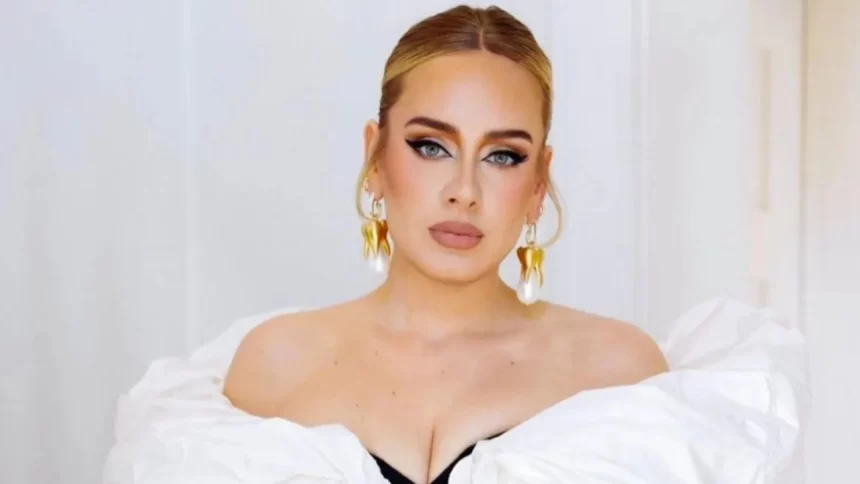 Cantora Adele, acusada de plágio, usando vestido branco em foto formal