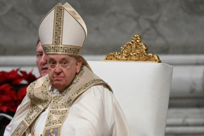 Papa Francisco sentado em uma cadeira, usando vestes litúrgicas douradas, durante a Missa do Galo na Basílica de São Pedro, Vaticano