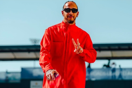 Lewis Hamilton veste jaqueta vermelha em evento