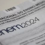 Caderno branco da prova do ENEM 2024 em destaque, sobre a mesa