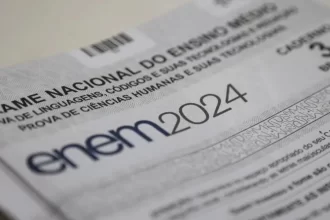 Caderno branco da prova do ENEM 2024 em destaque, sobre a mesa