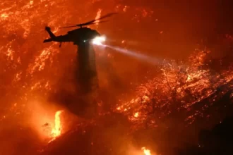 Helicóptero jogando água para ajudar a reduzir o fogo