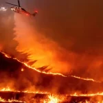 Helicóptero sobrevoando área sendo atingida pelo grande incêndio de Los Angeles, na tentativa de controlar as chamas