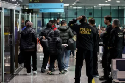 Agentes da receita federal recebendo pessoas que estão retornando para o Brasil após serem deportadas dos EUA