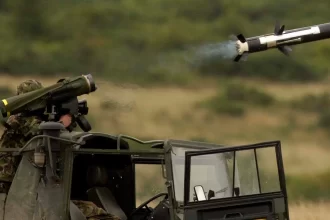 Homem dentro de carro de guerra lançando um míssil