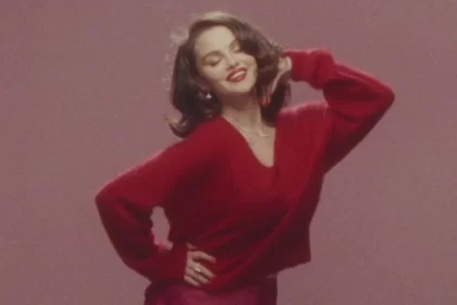 A cantora e atriz Selena Gomez posando de vermelho em uma referência ao seu novo clipe com o noivo