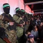 Palestinos e combatentes do Hamas presentes em cerimônia fúnebre