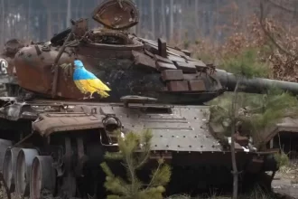 Carcaça de um tanque de guerra destruído mostra um pombo com as cores da bandeira ucraniana e um ramo no bico