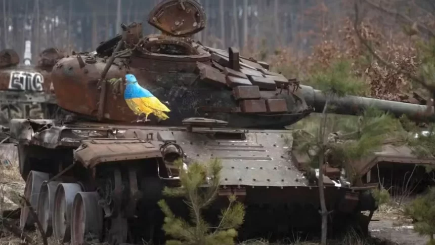 Carcaça de um tanque de guerra destruído mostra um pombo com as cores da bandeira ucraniana e um ramo no bico