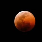 Eclipse lunar total de 2025 visto no céu com coloração avermelhada da Lua de Sangue.