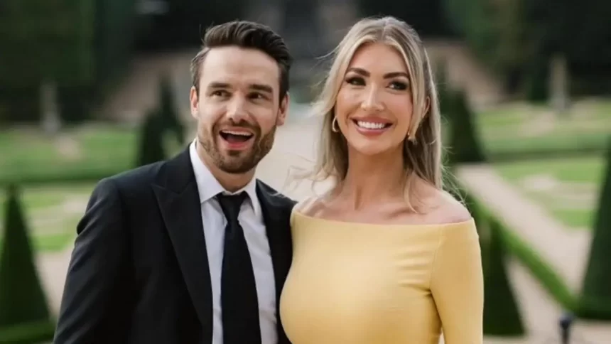 Liam Payne e Kate Cassidy sorrindo e felizes diante de um jardim