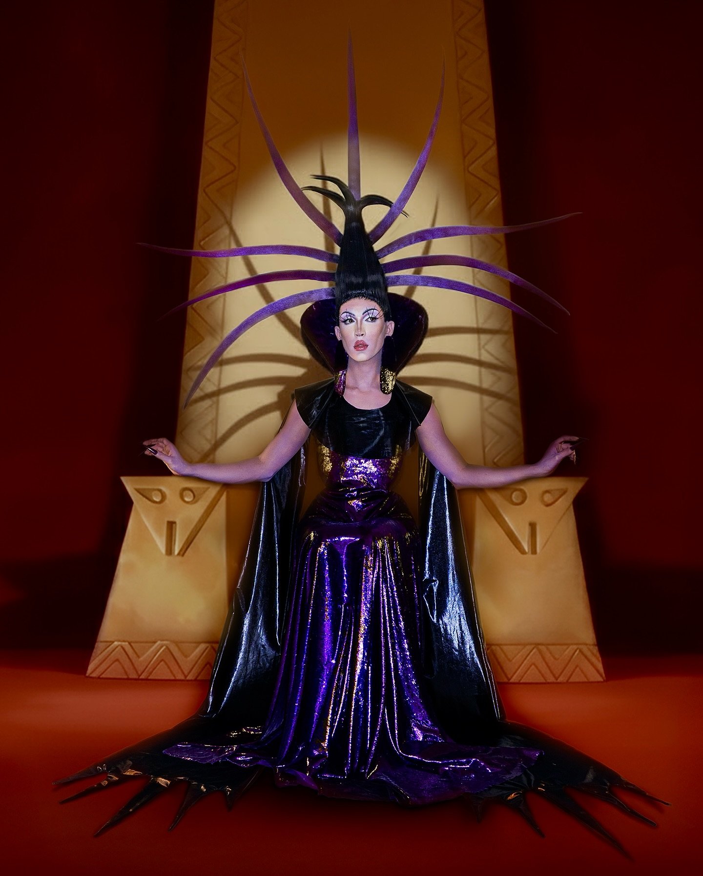 maquiador ismeiow sentado em um grande trono com fantasia da vilã Izma