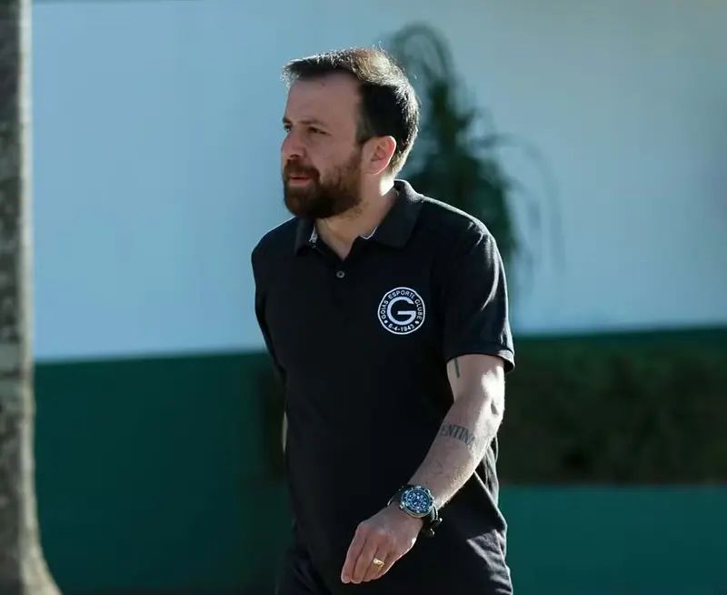 Crise no Goiás: Mancini e Andrino deixam o clube em meio à queda na Série B Diretor de futebol do Goiás, Lucas Adrino, vestindo uma camisa polo preta com o escudo do Goiás