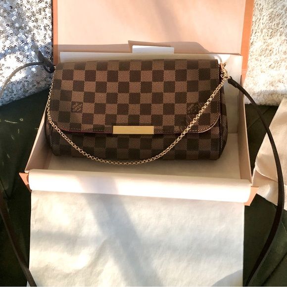 Bolsa icônica da Louis Vuitton dentro de uma caixa, com seu padrão quadriculado e marrom.