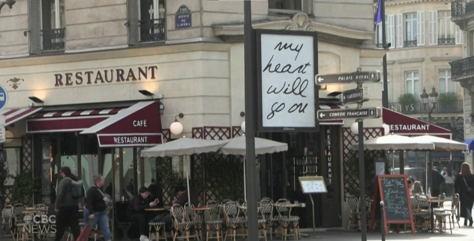 Cartaz escrito "my heart will go on" em uma rua de Paris
