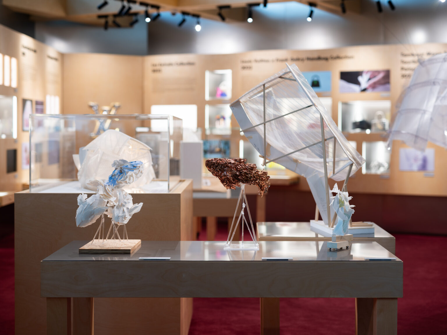 Louis Vuitton celebra duas décadas de Frank Gehry na Art Basel Hong Kong Estande da Louis Vuitton em uma feira de arte com maquetes artísticas sobre mesas de madeira clara